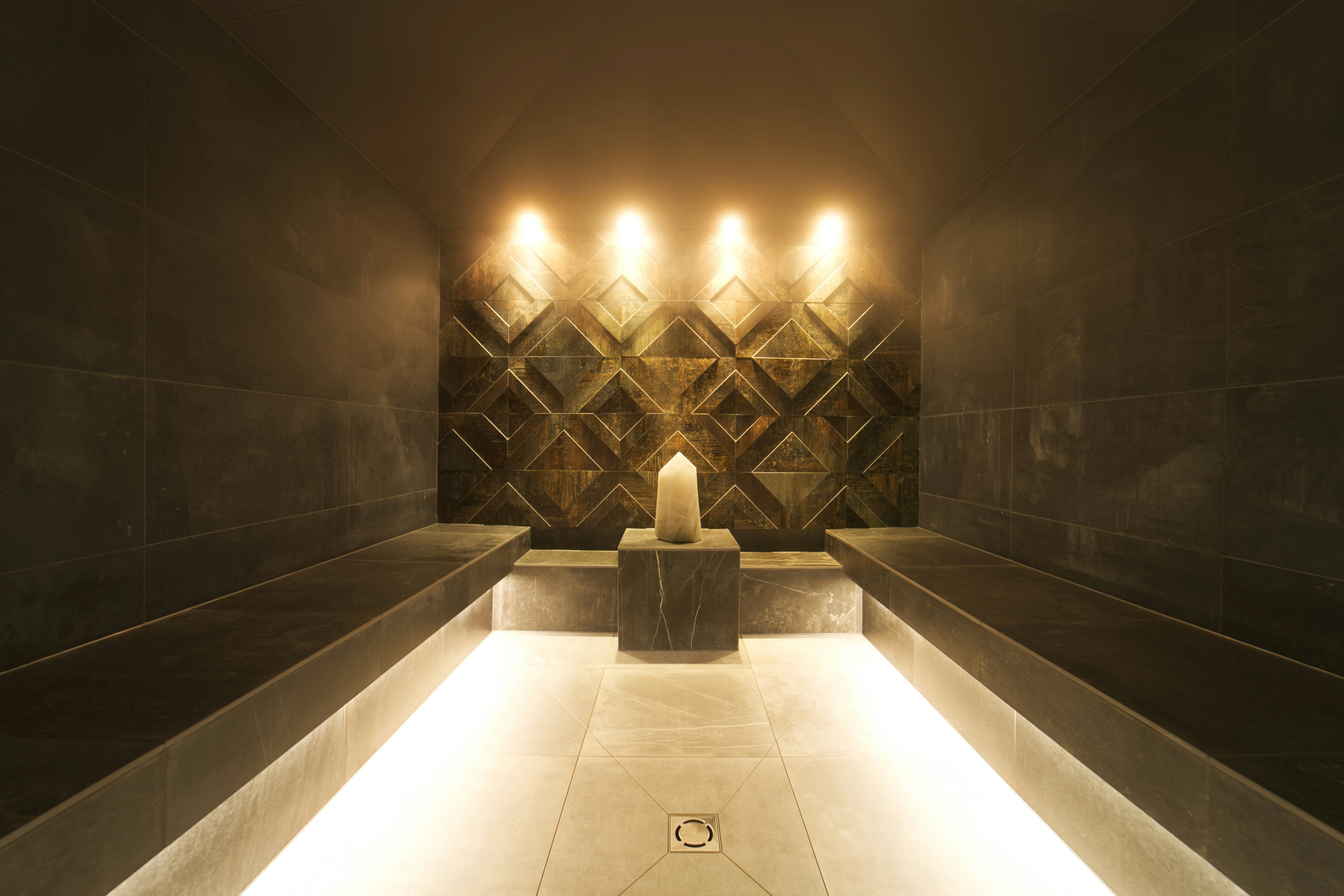 Candlelit stone treatment room, warmly lit