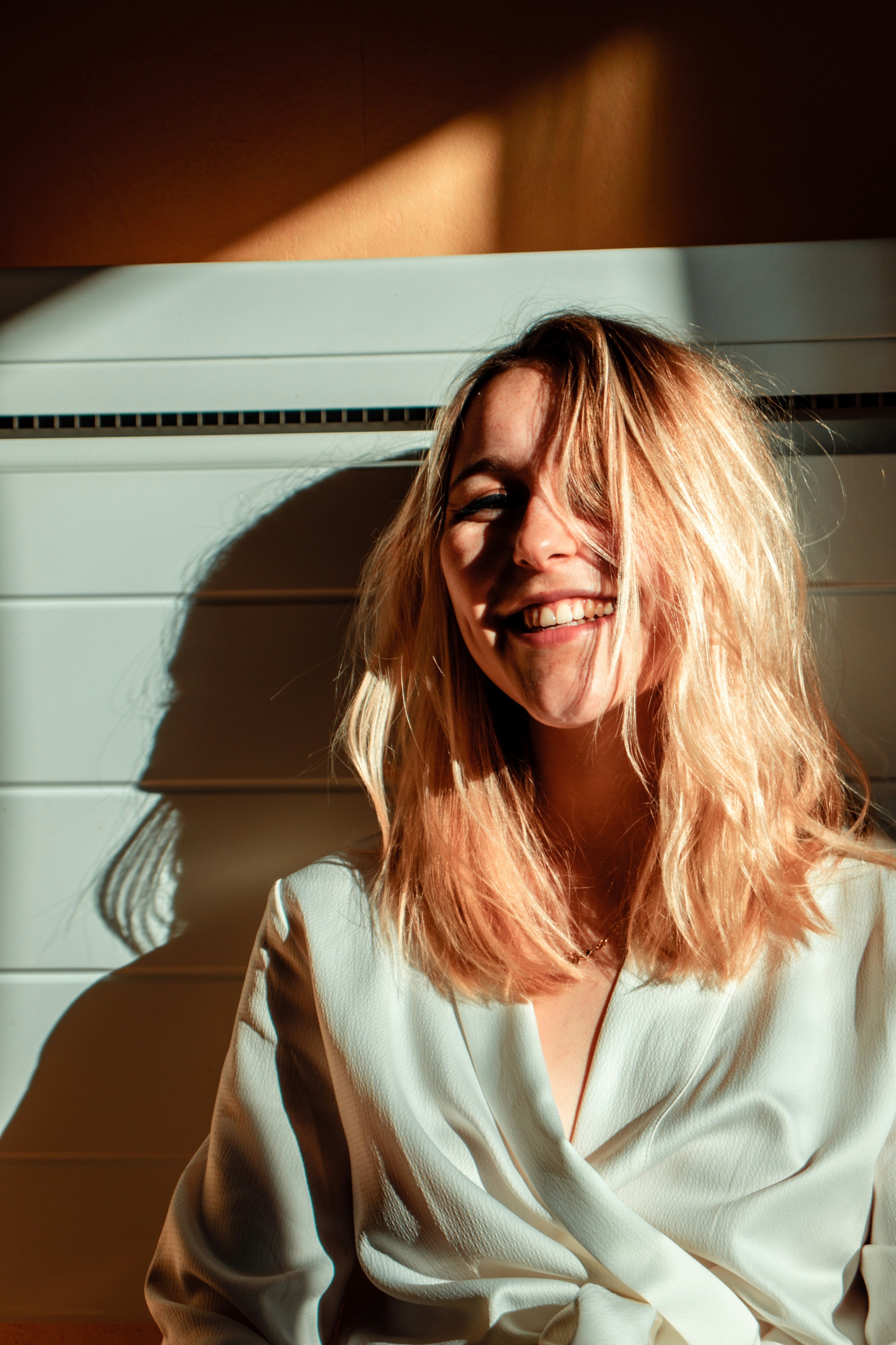A woman laughing, lit by warm afternoon light